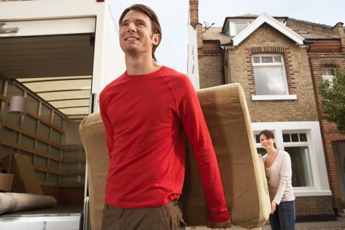 Movers carrying furniture through a Hither Green property